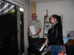 Pianiste Tsarina begeleid het koor op het keyboard, Fred (man van Irene) is behulpzaam bij het vasthouden van de muziek